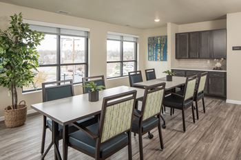 A dining room with a table and chairs.